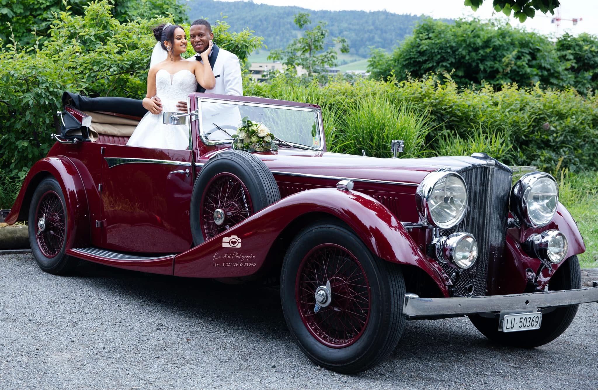 Bride and groom by classic car